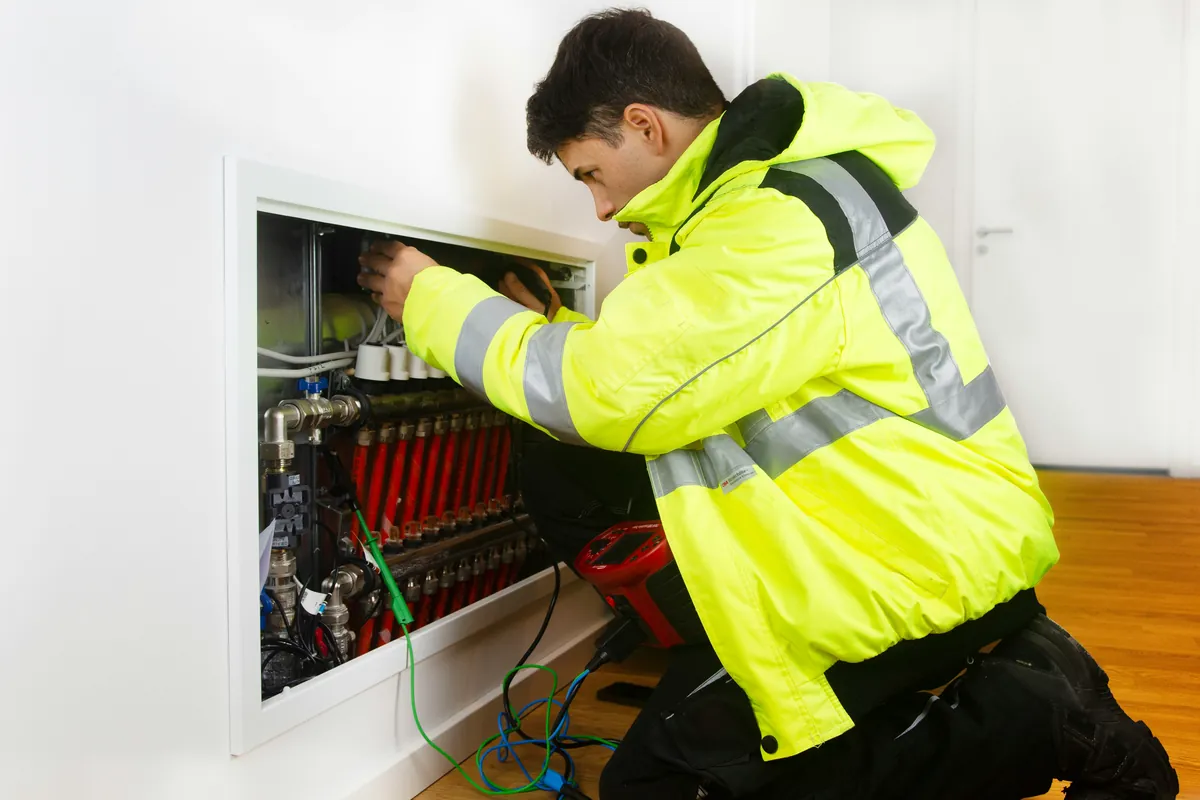 Technician servicing a residential heating manifold.