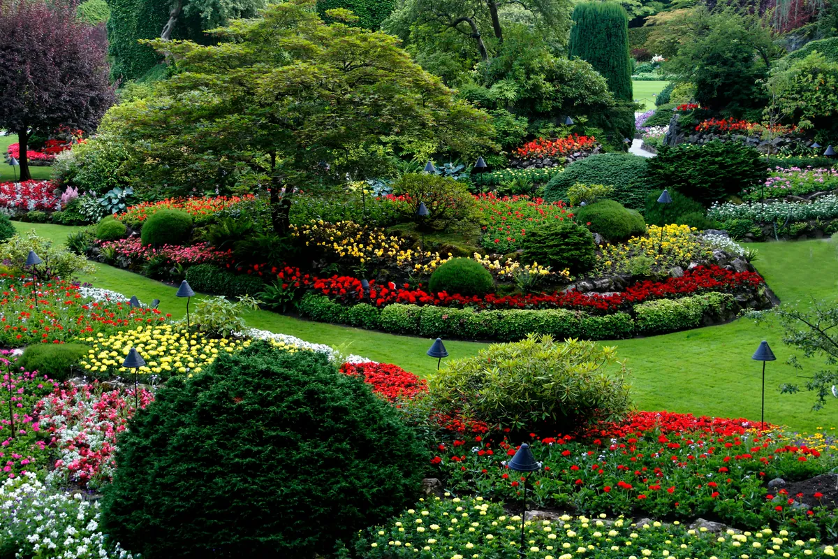 Landscaped garden with trimmed shrubs, flower beds and green lawns.
